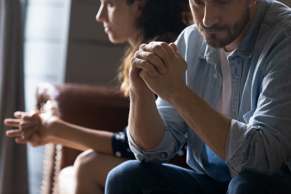 Crop-Close-Up-of-Unhappy-Young-Couple-Sit-Separate-Have-Problems-in-Relationship-Think-of-Breakup-or-Divorce