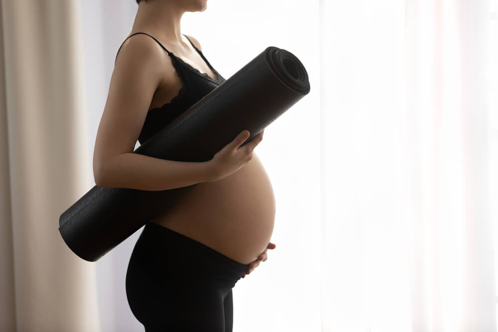 Close Up Cropped Profile of Pregnant Woman in Black Sportswear Holding Yoga Mat, Touching Belly, Young Future Mom Ready for Gymnastics or Exercise, Healthy Lifestyle and Sport During Pregnancy