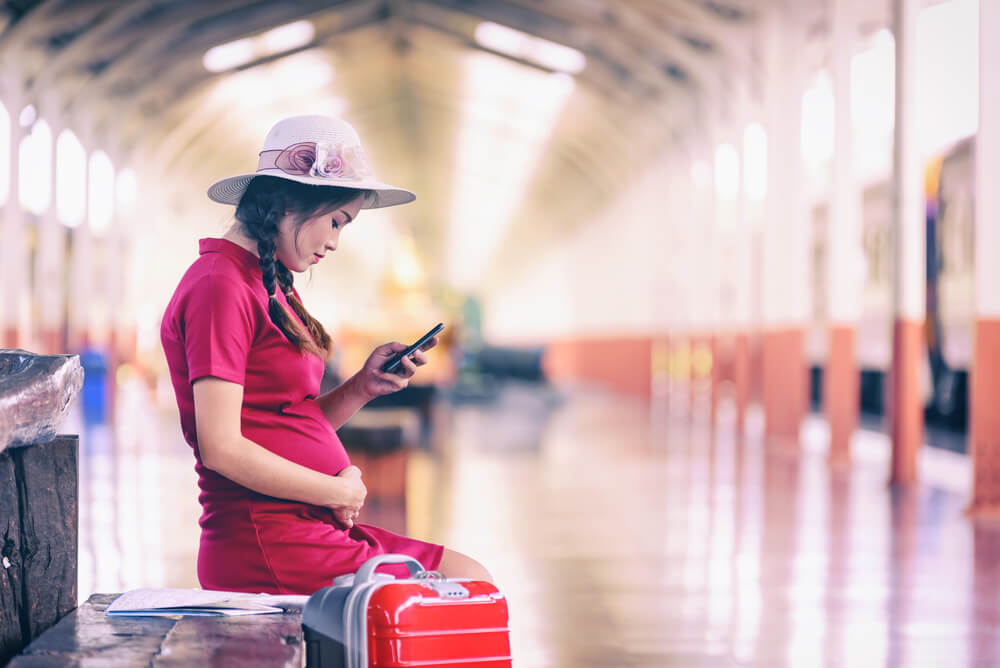 Pregnant Woman Tourist With Look Searching Direction on Location Phone With Tourists Bag or Luggage While Traveling by Train