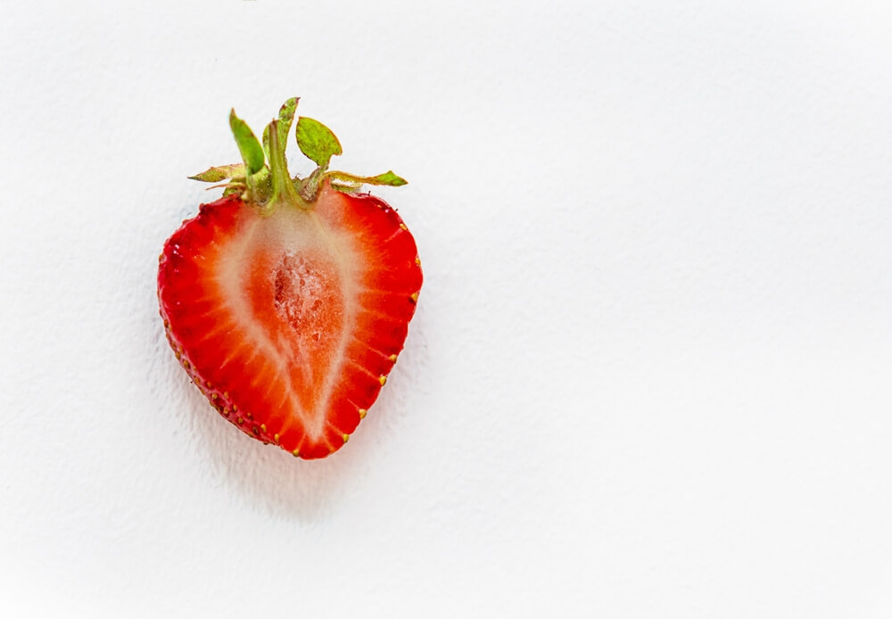 Strawberry Cut In Half Imitating Female Clitoris Isolated On The White Background.
