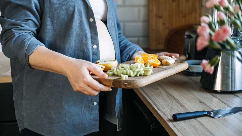 Fruits To Avoid During Pregnancy Food Allergy And Pregnancy Pregnant Woman Cutting Fruits In The Home Kitchen