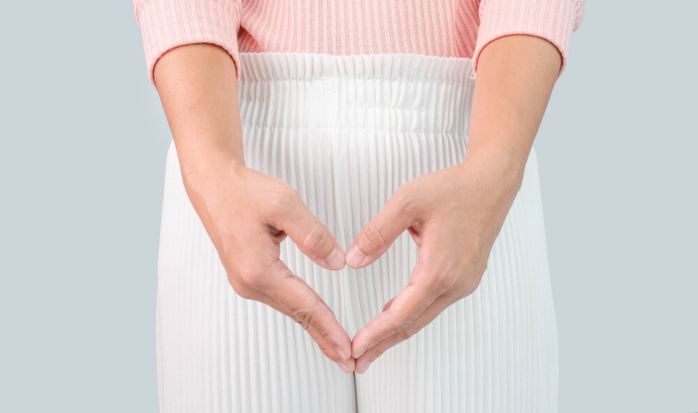 Close up view of young woman and Hand is a symbol of heart over her crotch.
