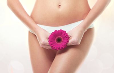 Girl in Underwear Holding a Pink Flower Over Her Pelvic Region
