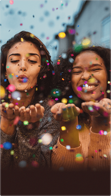 Two Girls Blowing Colourful Glitter