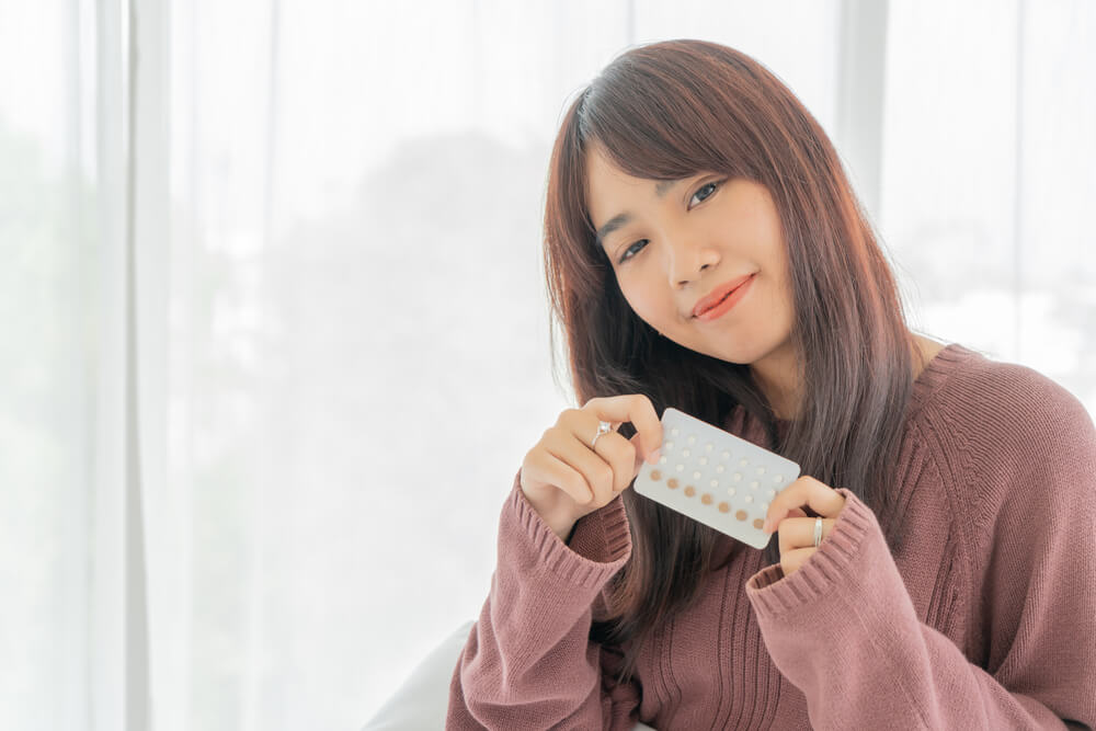 Beautiful Asian Women Holding Birth Control Pill