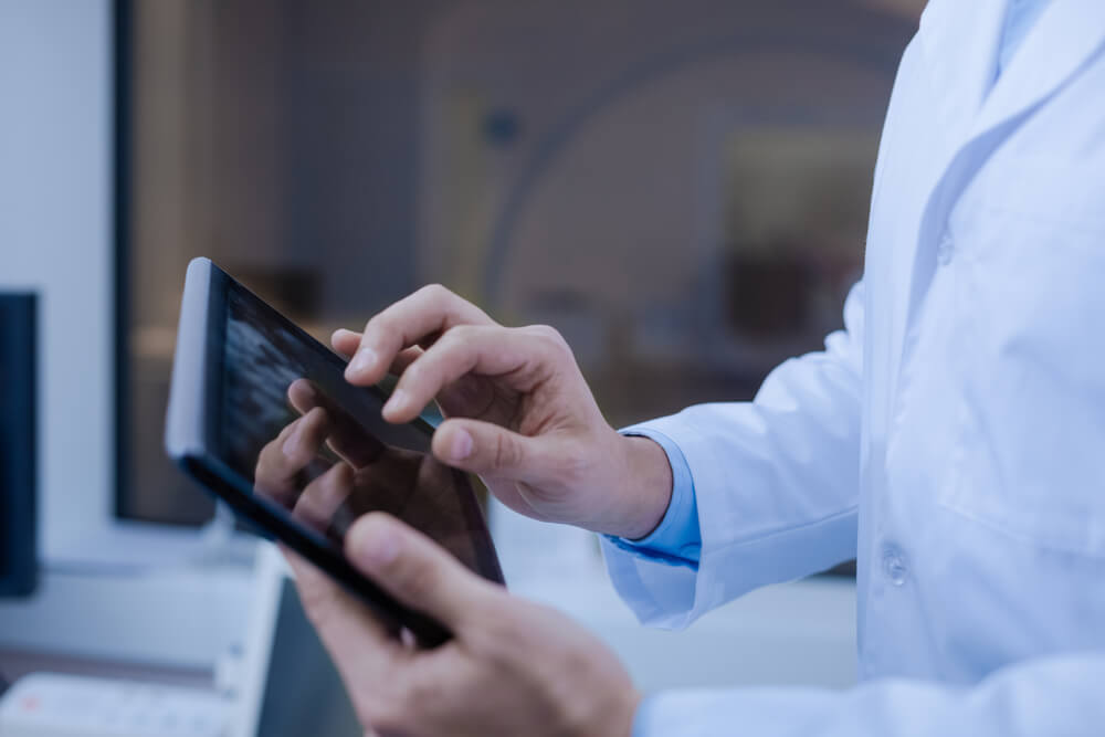 Close Up of a Tablet Being in Doctors Hands
