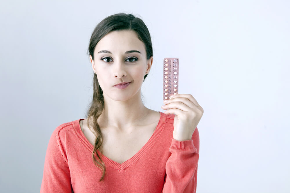 Woman Holding Contraceptive Pills With Unsure Face Expression