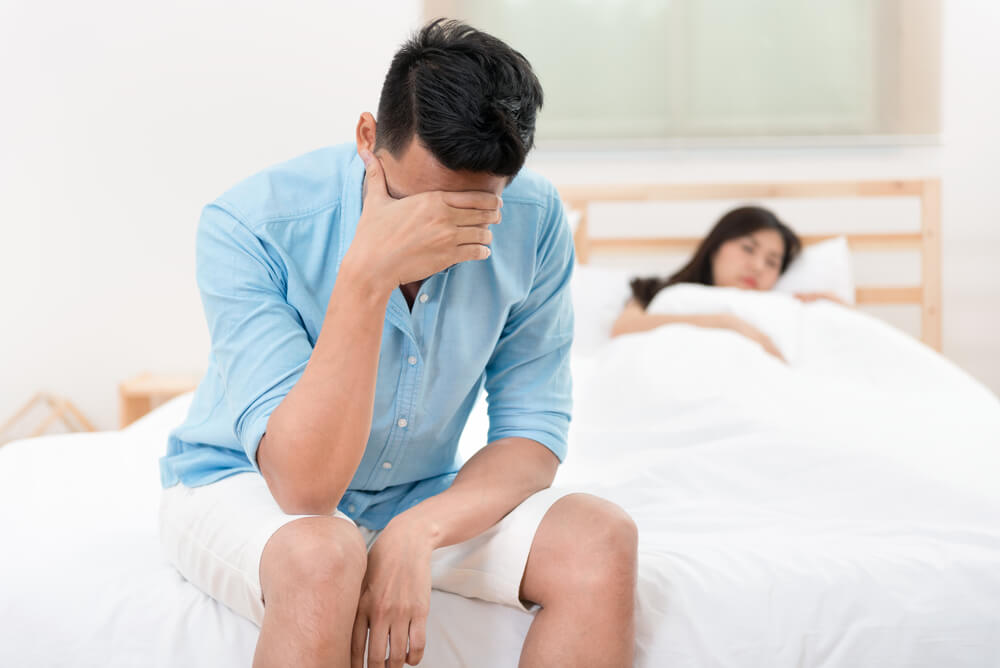 Husband Unhappy and Disappointed in the Erectile Dysfunction During Sex While His Wife Sleeping on the Bed.