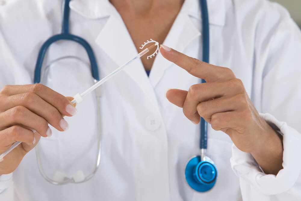 Yound Doctor Holding an Iud Birth Control Copper Coil Device