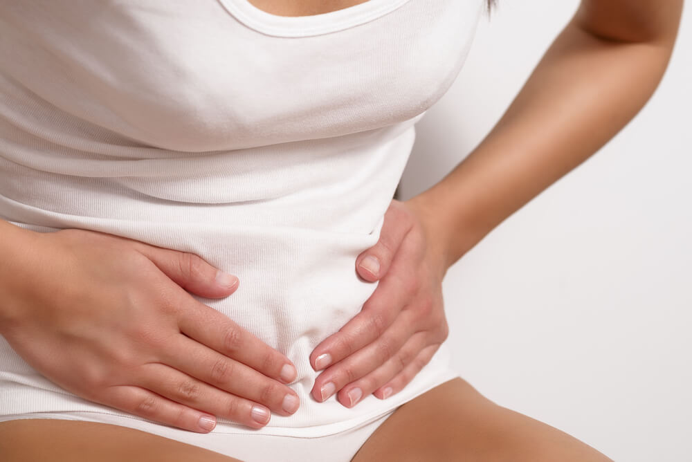Woman With Her Monthly Menstrual Pains Clutching Her Stomach With Her Hands