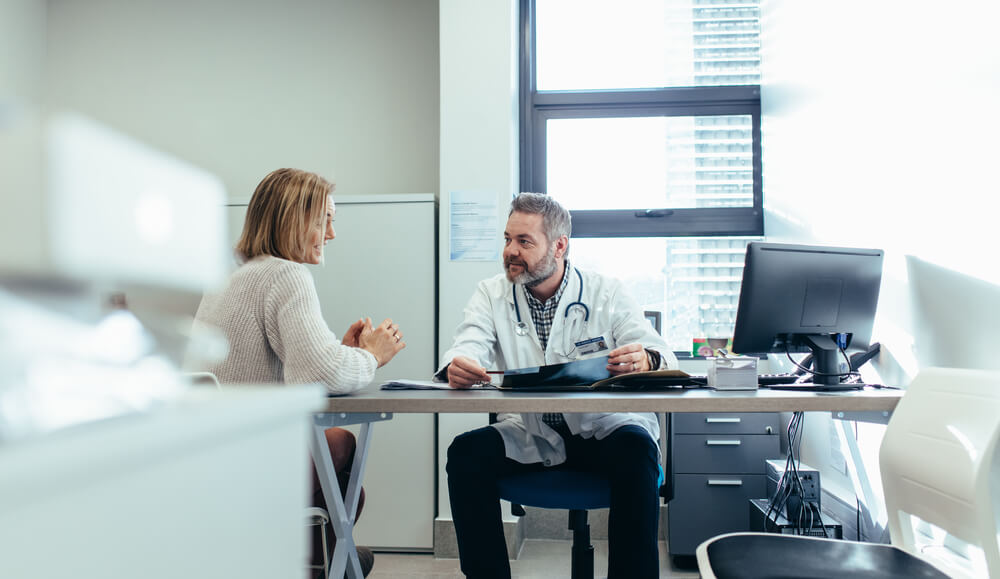 Medical Specialist Discussing With Female Patient in His Clinic.