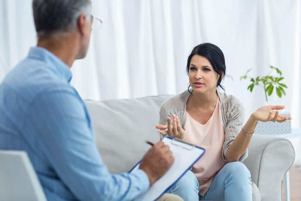 Pregnant Woman Talking to Doctor at Home