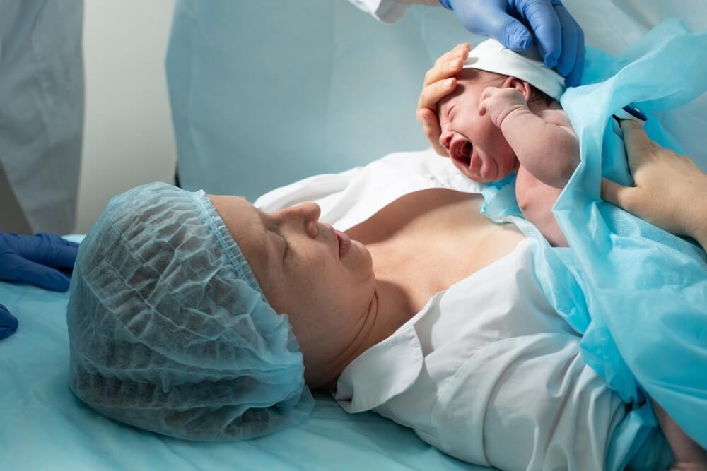 Mother Looks at Her Newborn Baby in Hospital