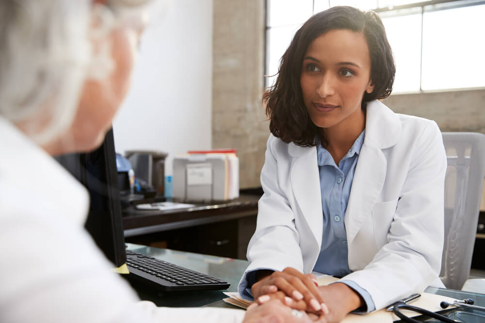 Young Female Doctor in Consultation With Senior Patient