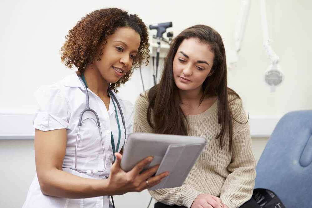 Nurse Showing Patient Test Results on Digital Tablet