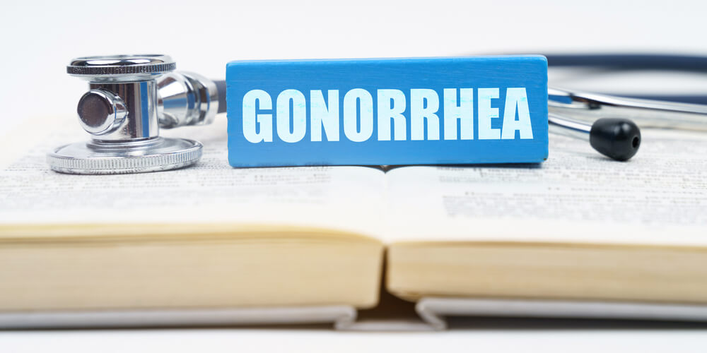 Medicine Concept. On the Book Is a Stethoscope and a Jenga With the Inscription - Gonorrhea