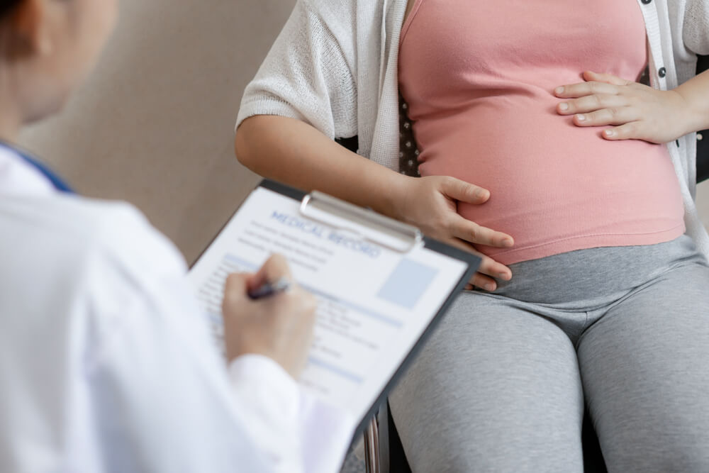 Happy Pregnant Woman Visit Gynecologist Doctor at Hospital or Medical Clinic for Pregnancy Consultant