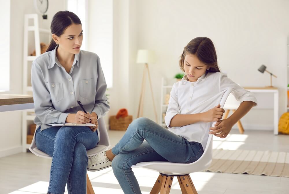 School Psychologist Talking to Child With Behavior Issues. 