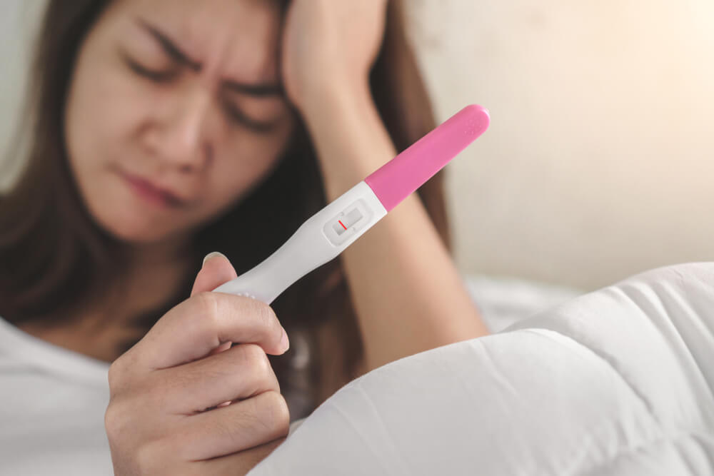 Wellness and Healthy Concept, Infertility Problem,Unhappy Young Woman Holding Pregnancy Test Showing a Negative Result, Selective Focus.