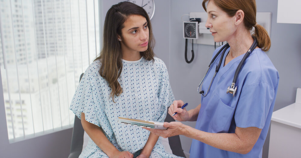 Portrait of Hispanic Woman Going Over Health History With Senior Nurse