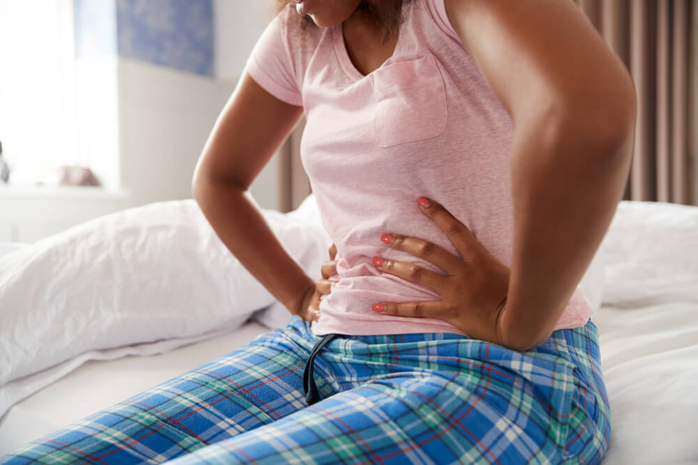 Woman Wearing Pajamas Suffering With Period Pain