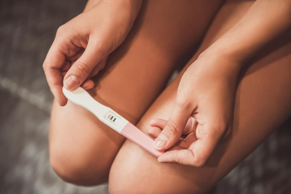 Cropped Image of Woman Holding a Pregnancy Test on Her Knees