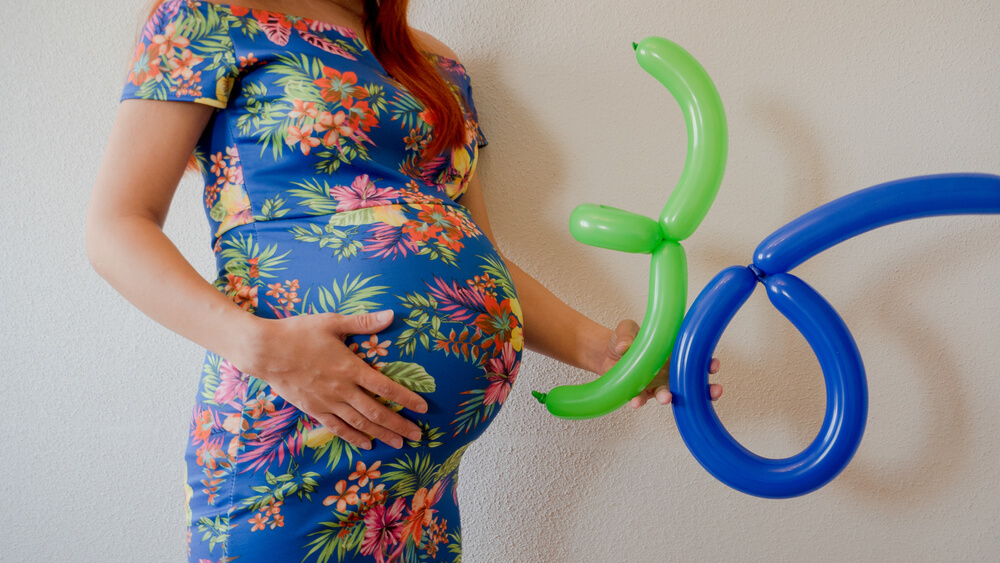 A Close up Photo of a Pregnant Young Woman Holding in Her Hands the Week Number Thirty Six 36 Next to Her Belly in a Beautiful Dress