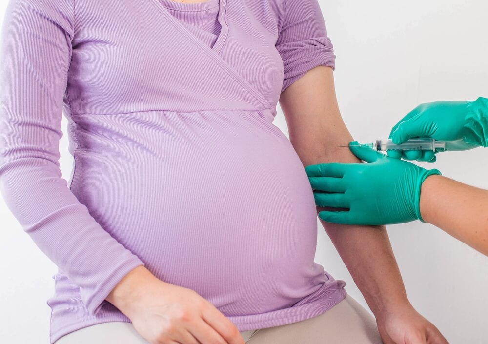 The doctor takes a biochemical blood test from a pregnant girl for infections and blood sugar levels