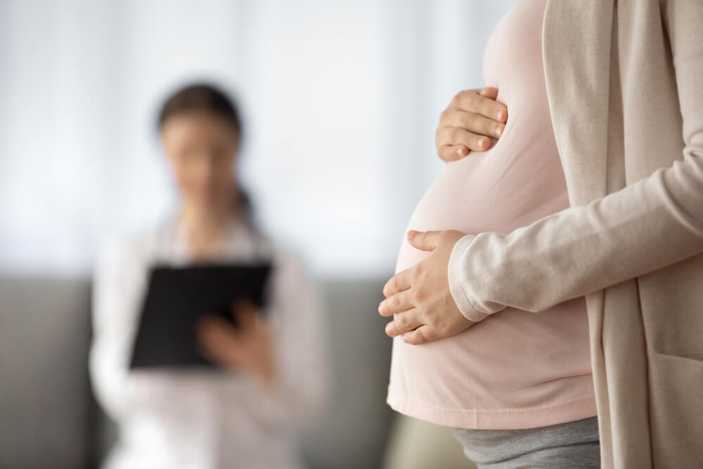 Close up of woman expecting baby having appointment with a doctor.