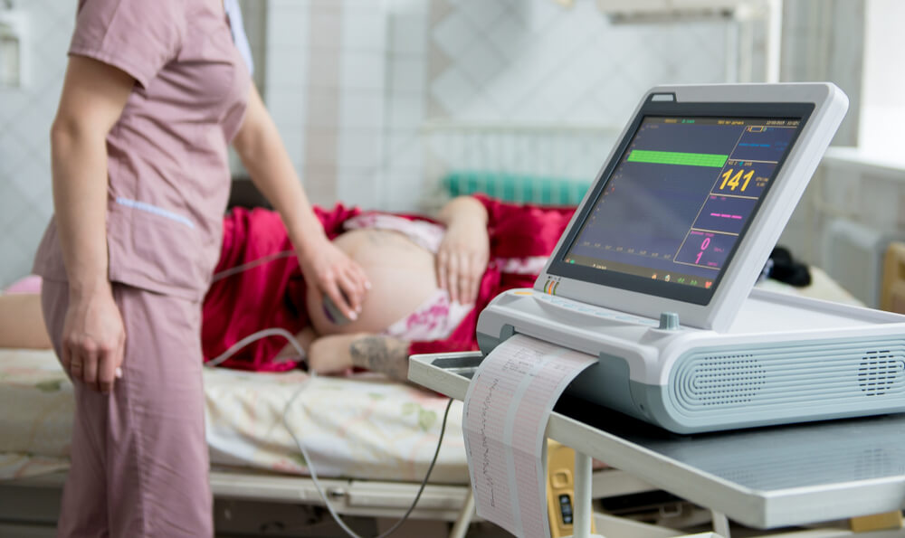 Pregnant woman with electrocardiograph check up for her baby, fetal heart monitoring