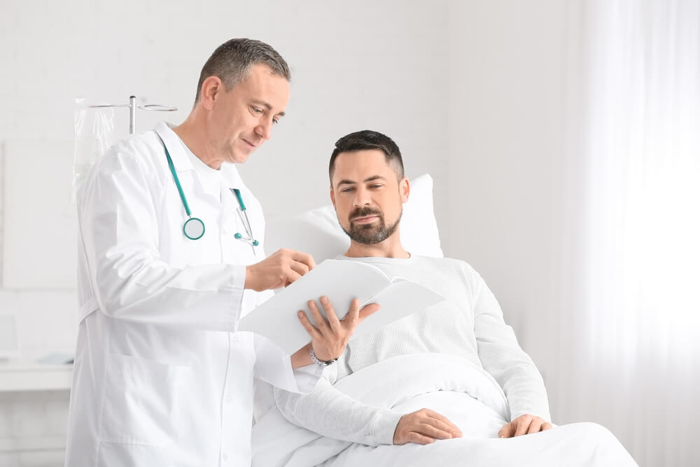 Doctor and Man Undergoing Course of Chemotherapy in Clinic