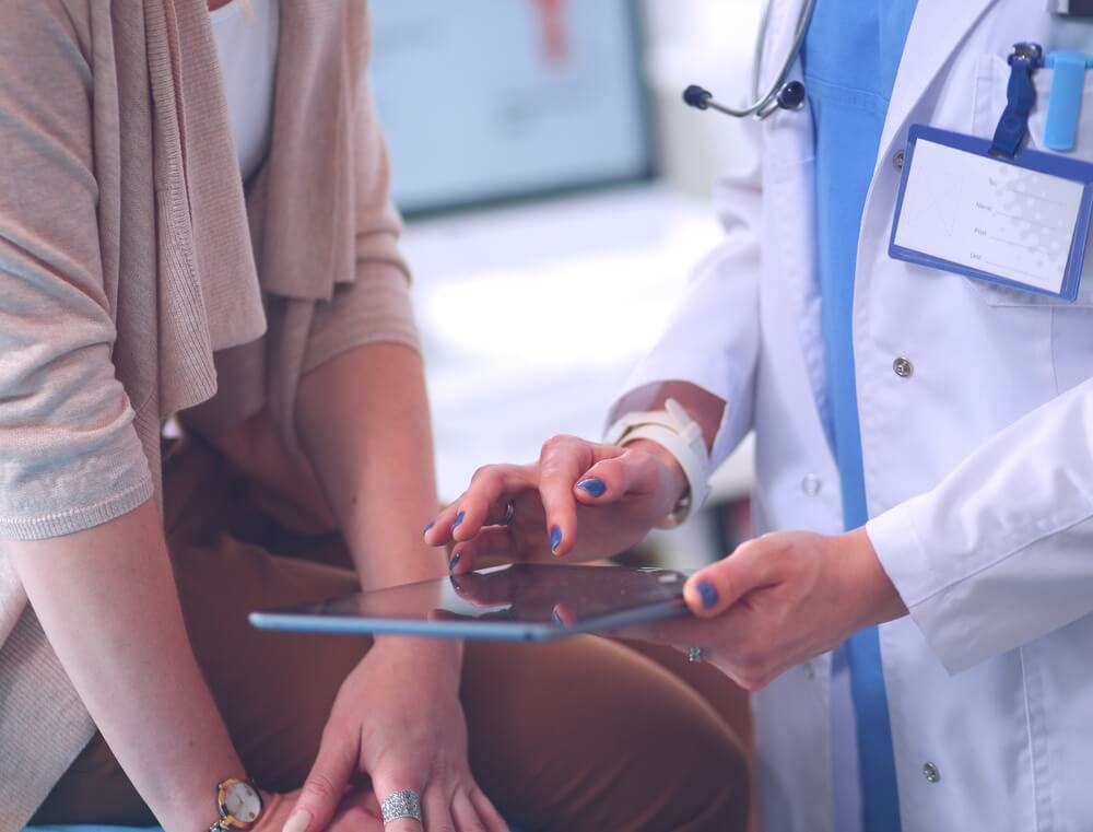 Doctor and Patient Discussing Something While Sitting at the Table