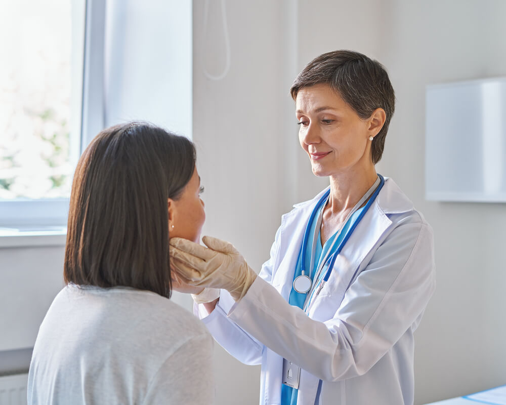 Female Doctor Wearing Gloves Checking Thyroid Glands