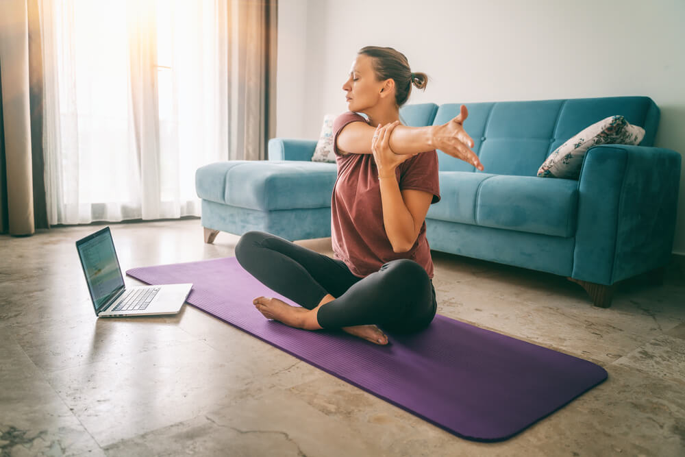 Attractive Young Woman Doing Yoga Stretching Yoga Online at Home.