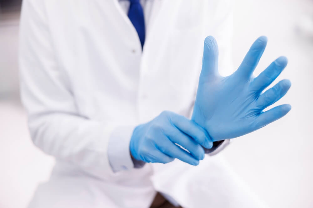 Doctor Putting on Protective Surgical Gloves While Working in Hospital