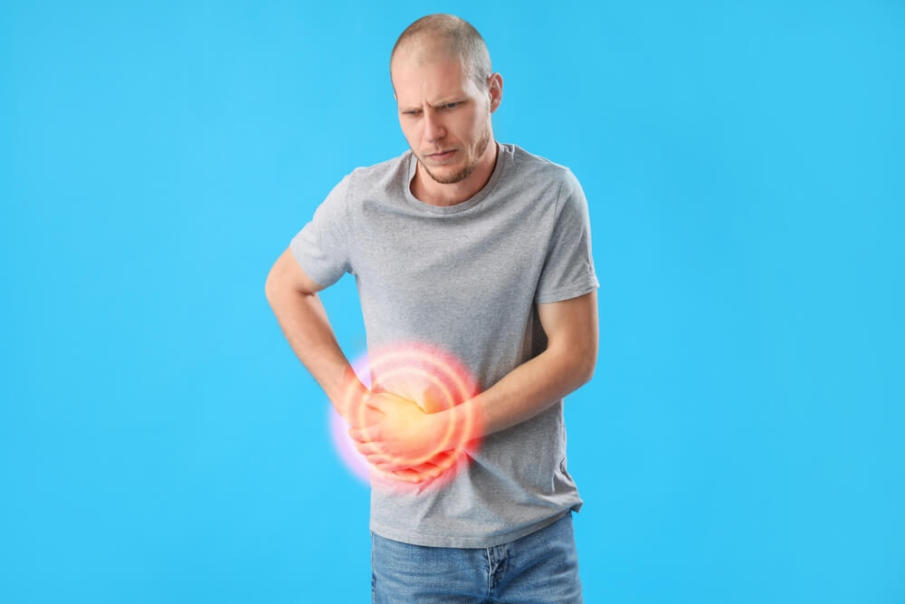 Young Man Suffering From Appendicitis on Blue Background