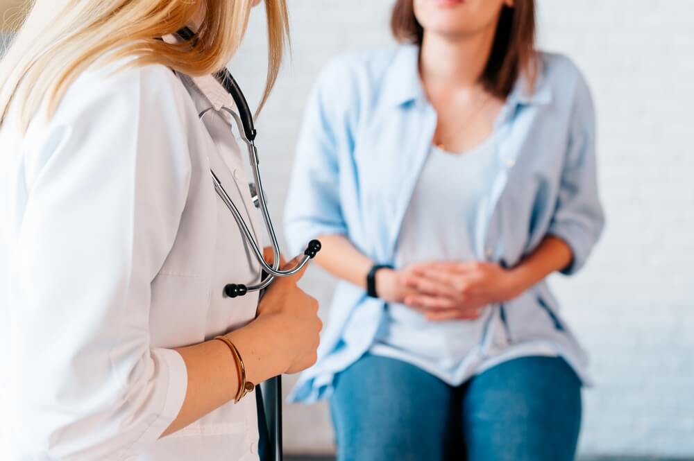 A woman in consultation with a doctor with abdominal pain.