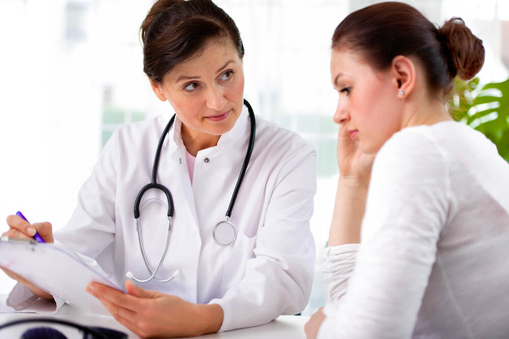 A doctor explaining diagnosis to her female patient.
