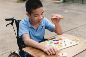 Special Need Child on Wheelchair Plays Fruit Jigsaw Puzzles