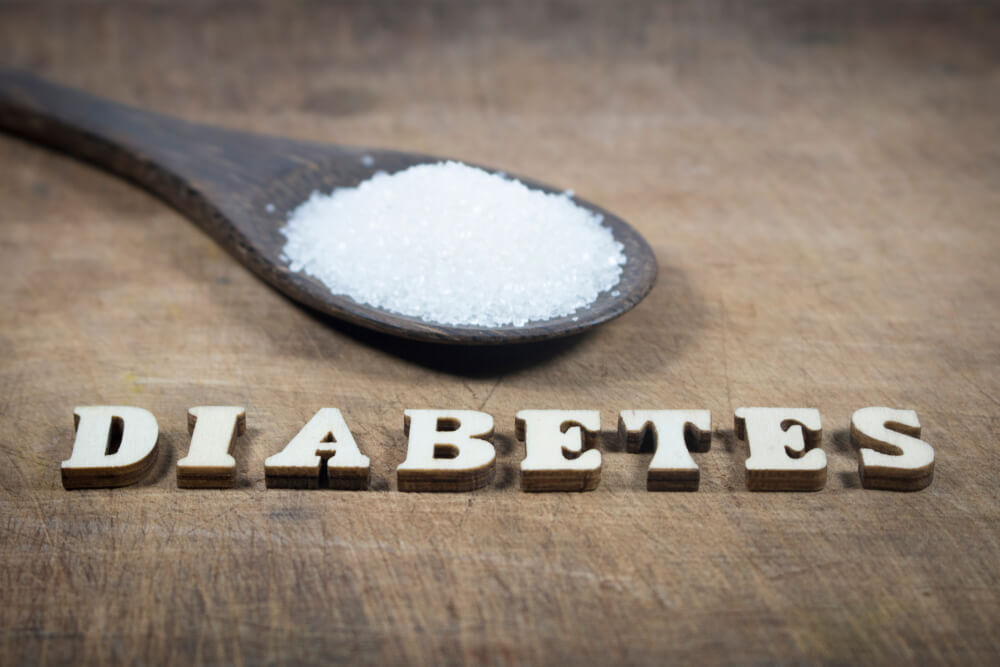 Diabetes Block Letters on Wooden Board Background With Sugar Pile on Wooden Spoon
