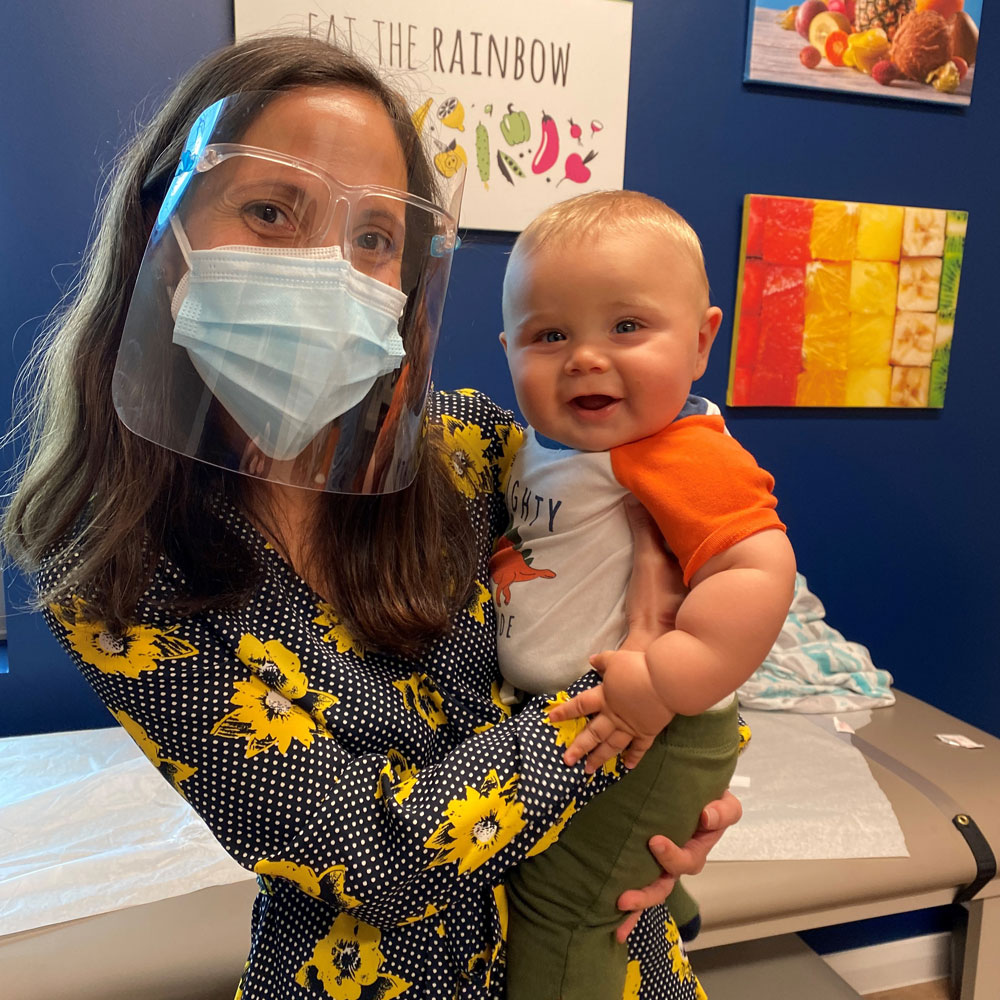 Dr. Miladys Palau holding a little boy