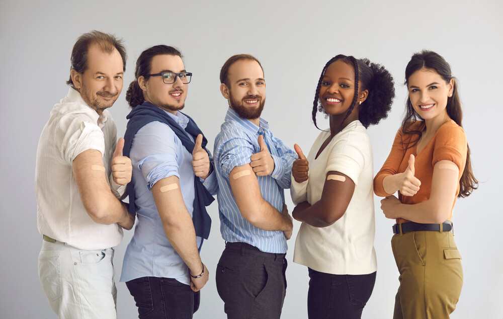 Studio Group Portrait of Happy Healthy Responsible Multiethnic Male and Female Citizens Giving Thumbs-up After Receiving Vaccine