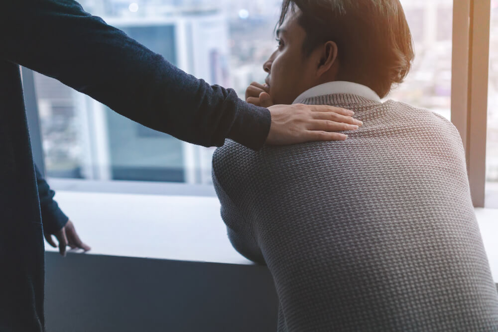  Psychologist Sitting and Holding Hand on Young Depressed Asian Man for Encouragement 