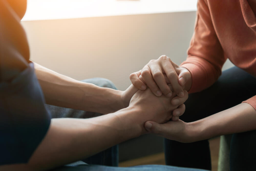  Psychologist Sitting and Touch Hand Young Depressed Asian Man for Encouragement