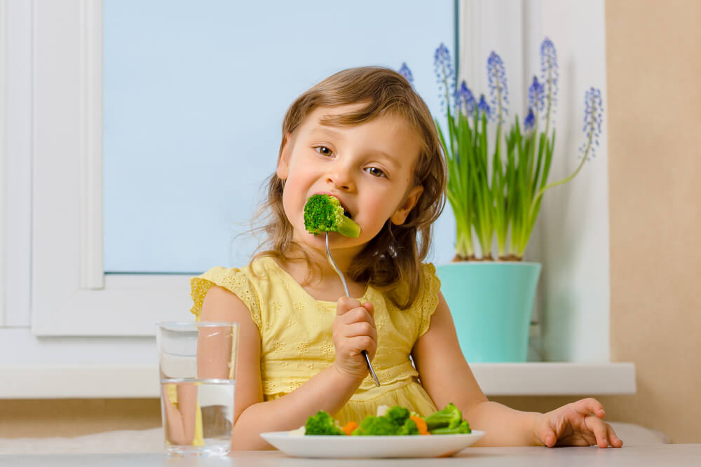 Kid Eating Broccoli With Enjoyment