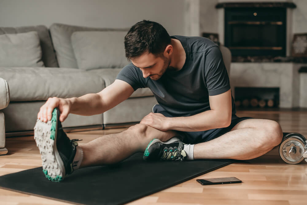 Man Doing Stretching Exercises on a Mat. Sport in Quarantine at Home