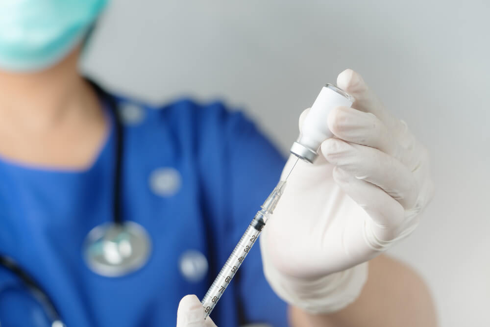 Nurse Holding Vaccine and Syringe Injection for Prevention