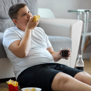 Fat Overweight Teenager Boy Has Bad Nutrition, Eat Unhealthy Food.