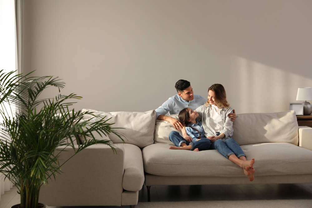 Family With Little Daughter Resting on Sofa in Living Room