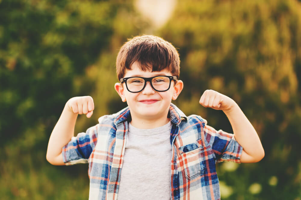 Strong, Smart and Funny Little Boy Playing Outdoors, Wearing Eyeglasses and Blue Plaid Shirt